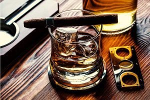 Mesa-con-Cigarros-Habanos,-cortador-de-puros-y-wisky-en-las-rocas