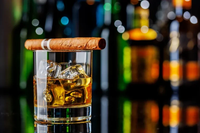 corte-en-v-para-puro-con-whisky-en-bar-de-lujo